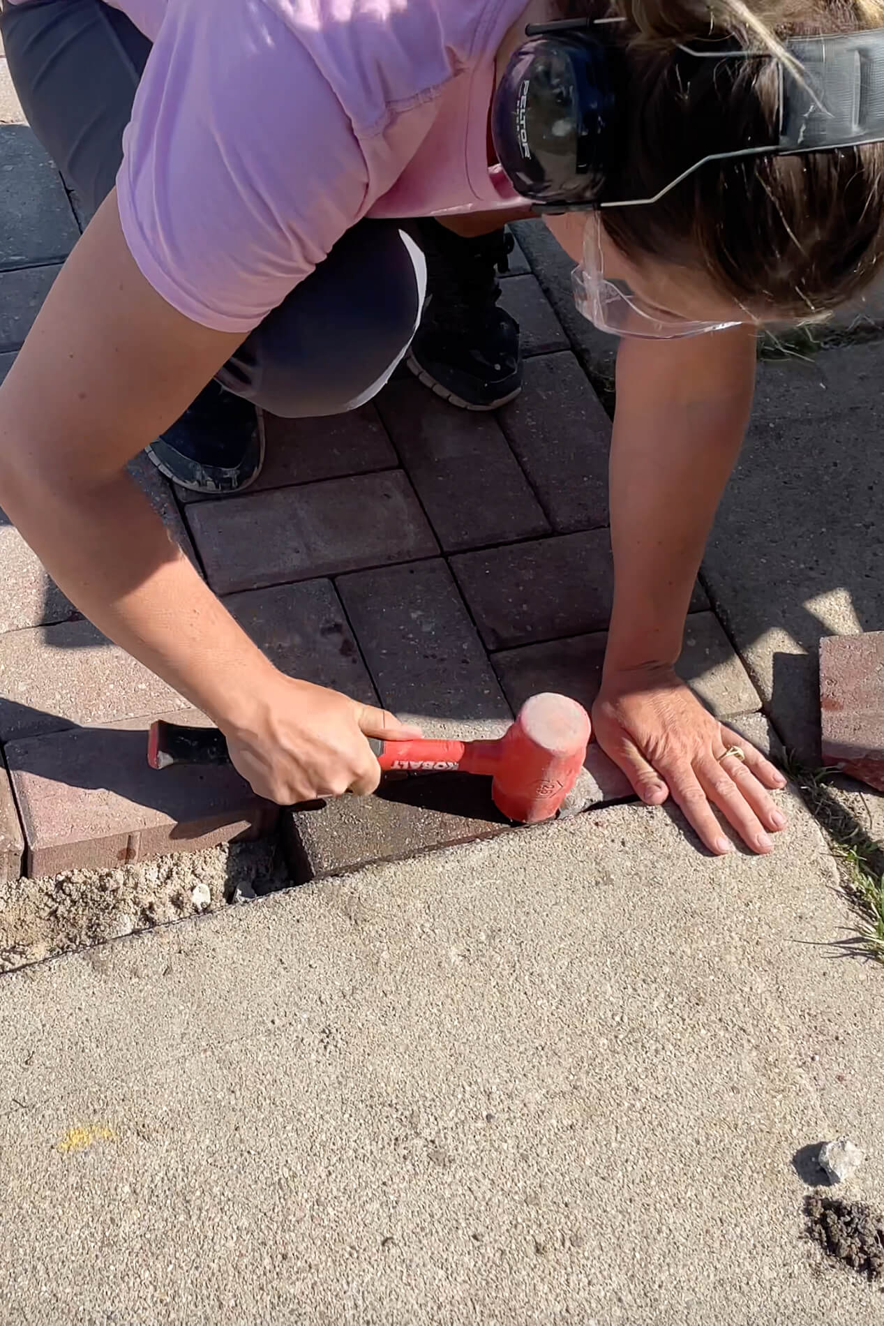 Using a rubber mallet while installing pavers.
